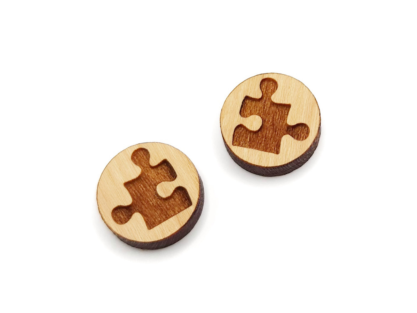 a pair of wooden buttons with a puzzle piece cut out of it