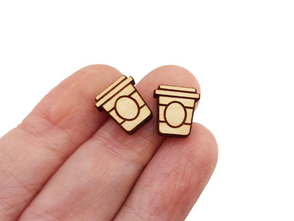 a hand holding a pair of wooden earrings