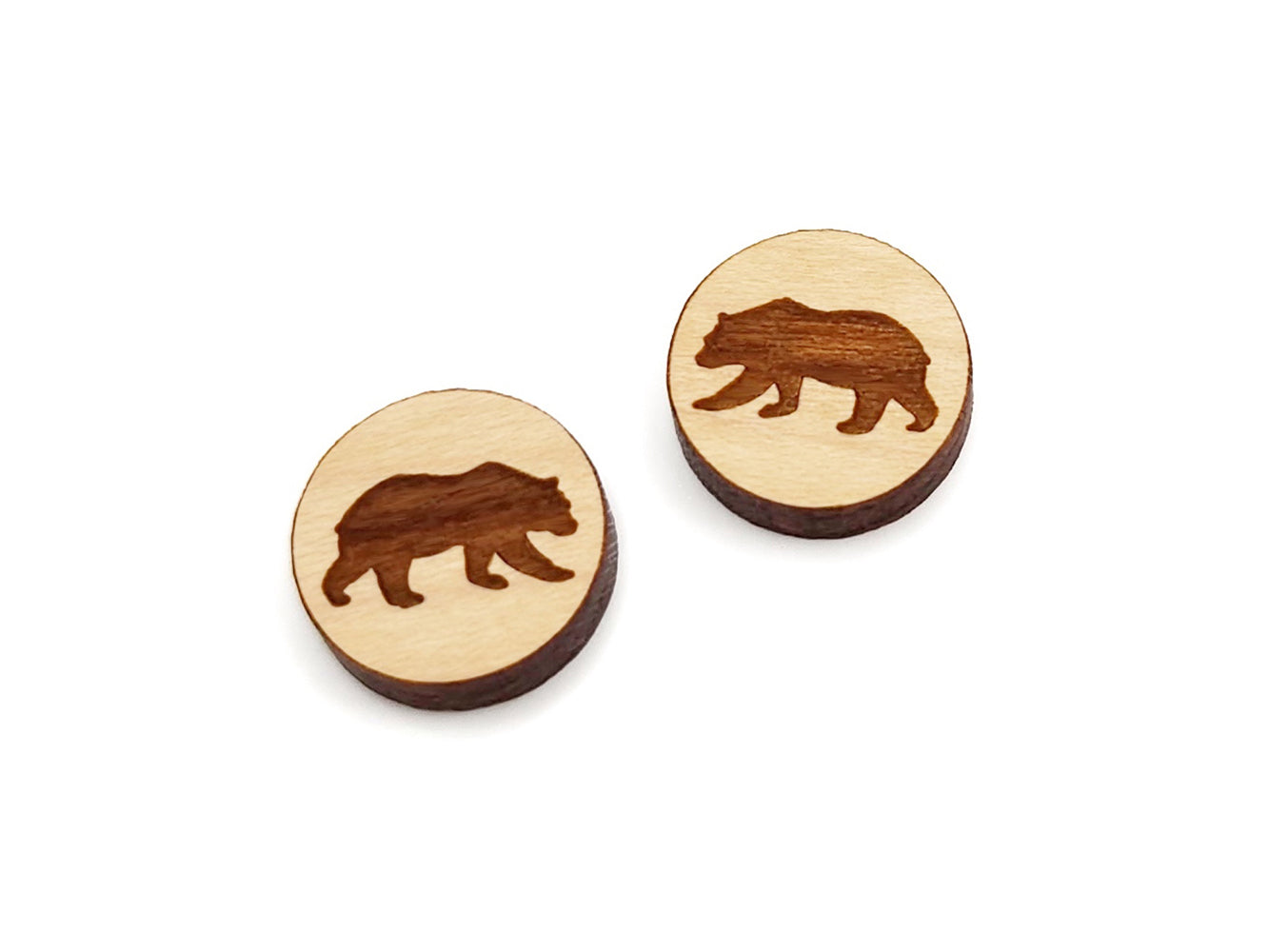 a pair of small round wooden cabochon blanks for stud earrings engraved with the silhouette of a bear