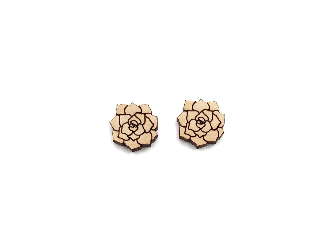 a pair of wooden earrings with a flower design