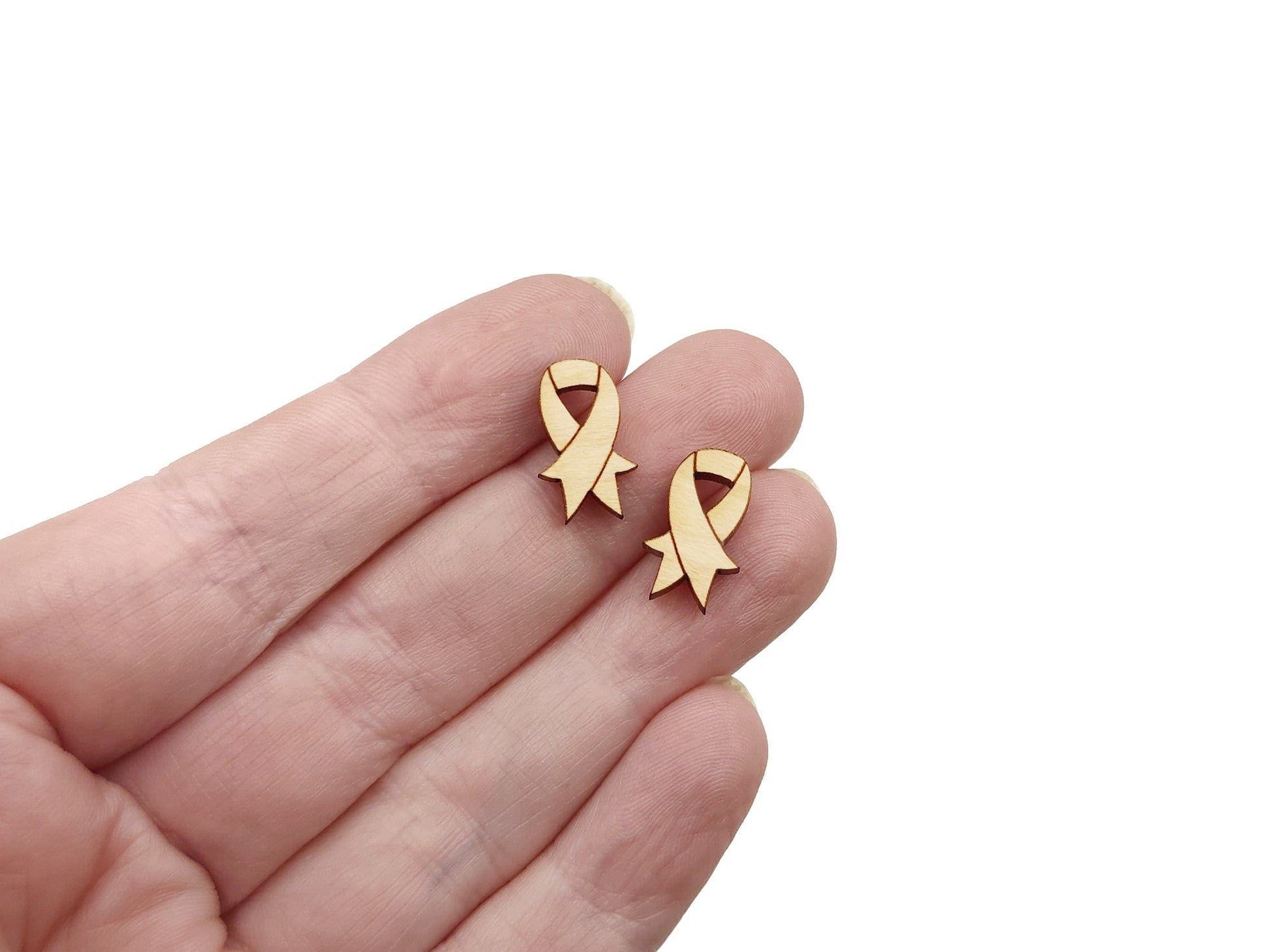 a hand holding a pair of gold earrings