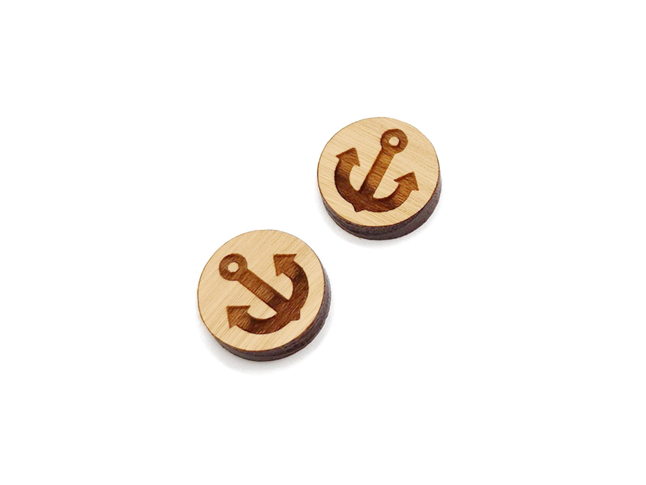 a pair of round wooden cabochon earring blanks engraved with an anchor silhouette
