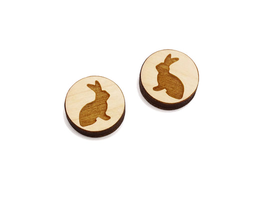 a pair of small round wooden cabochon blanks for stud earrings engraved with the silhouette of a bunny rabbit.