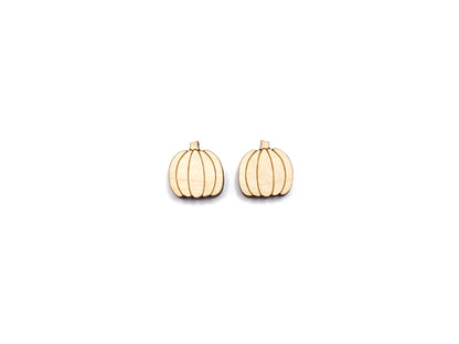 a pair of wooden cabochon stud earring blanks cut and engraved to look like pumpkins