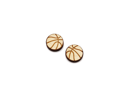 a pair of wooden cabochon stud earring blanks cut and engraved to look like a basketball