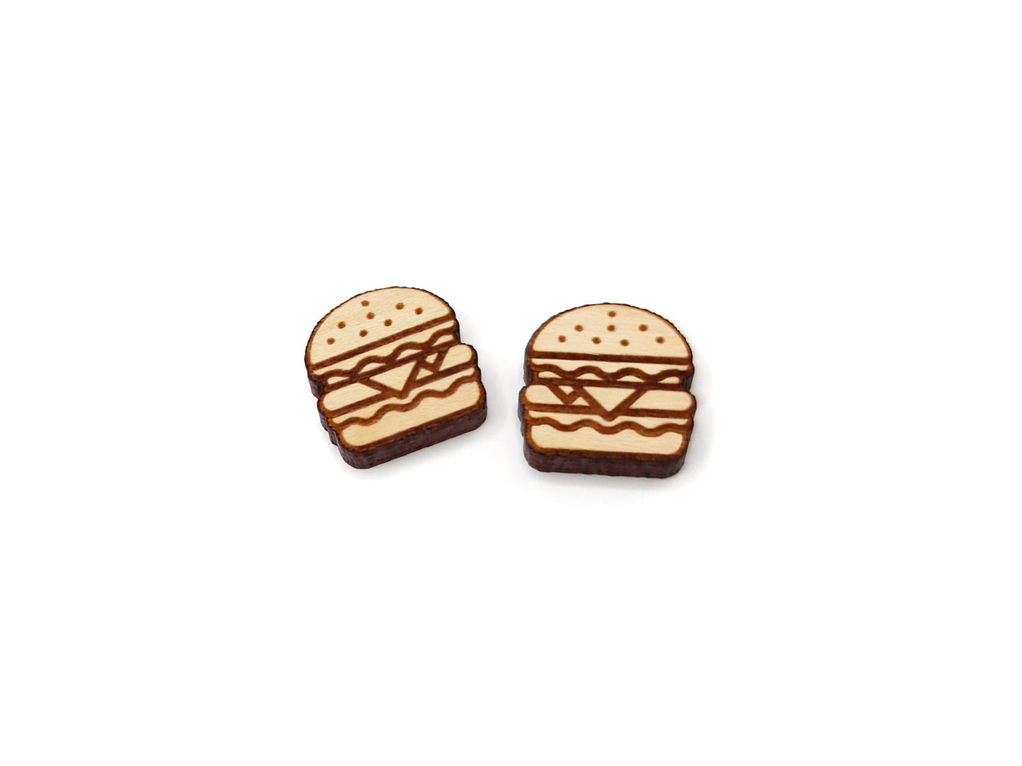 a pair of wooden cabochon stud earring blanks cut and engraved to look like a cheeseburger