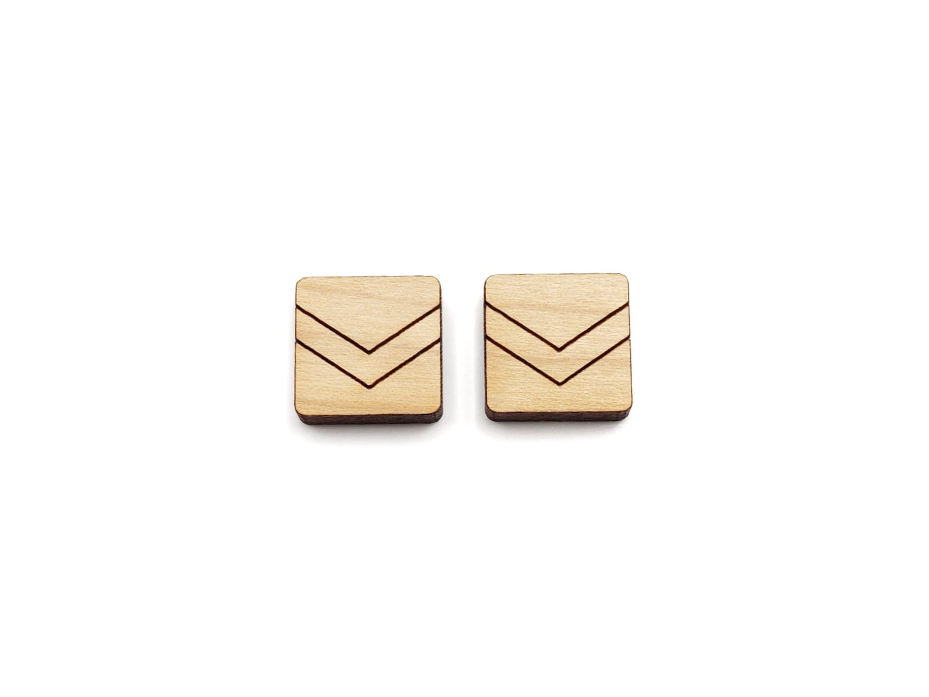 a pair of wooden cabochon stud earring blanks cut in a square shape and engraved with a chevron