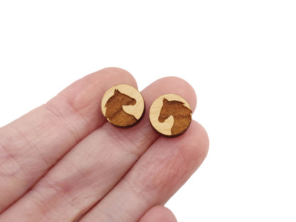 a hand holding a pair of wooden earrings