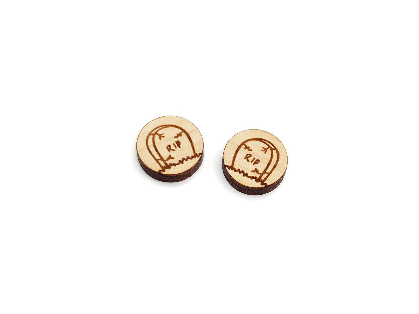 a pair of round wooden cabochon earring blanks engraved with a Halloween Tombstone