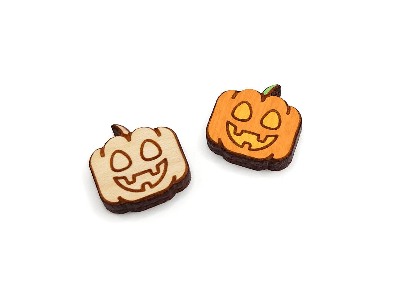 a pair of wooden cabochon earring blanks cut and engraved to look like a happy jack-O-lantern