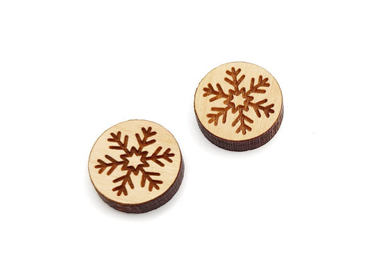 a pair of round wooden cabochon earring blanks engraved with a snowflake