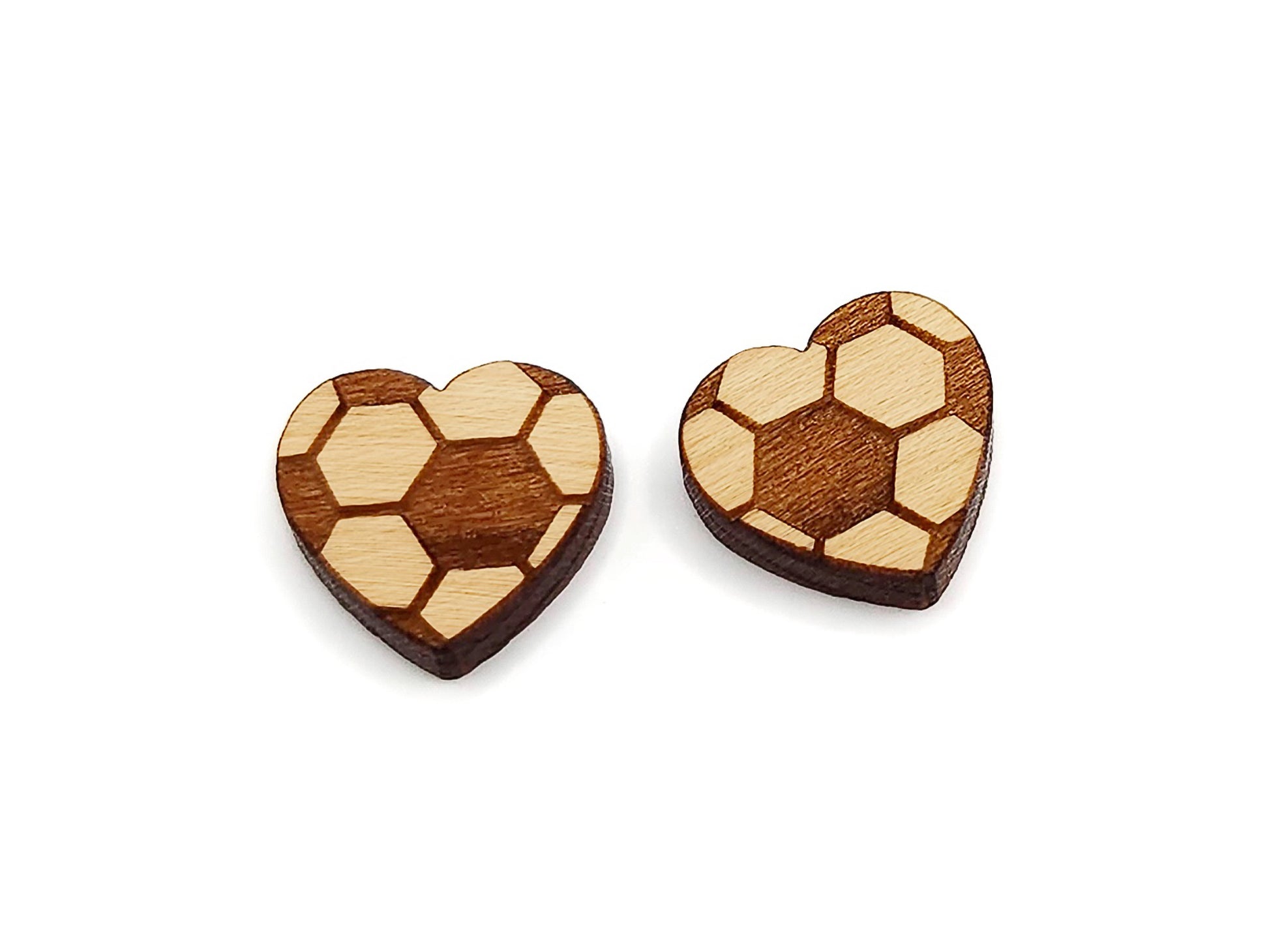 a pair of wooden cabochon earring blanks cut and engraved to look like a heart-shaped soccer ball