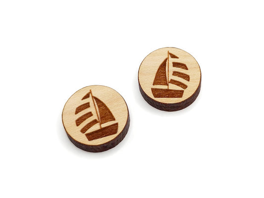 a pair of round wooden cabochon earring blanks engraved with a sailboat