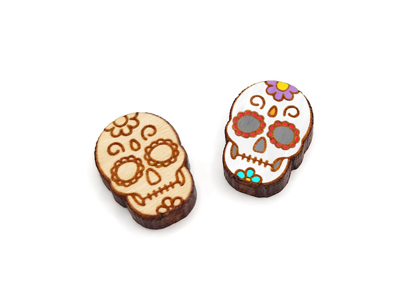 a pair of wooden cabochon stud earring blanks cut and engraved to look like a sugar skull