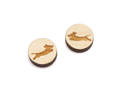 a pair of round wooden cabochon earring blanks engraved with a leaping dachshund