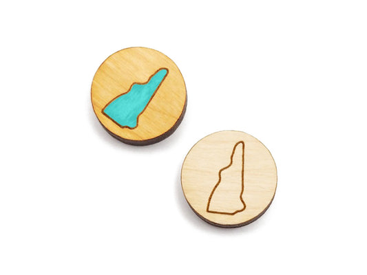 a pair of round wooden cabochon earring blanks engraved with an outline of New Hampshire