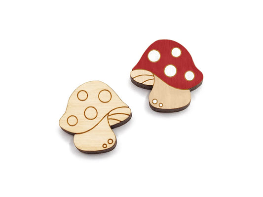 a pair of wooden cabochon stud earring blanks cut and engraved to look like spotted mushrooms