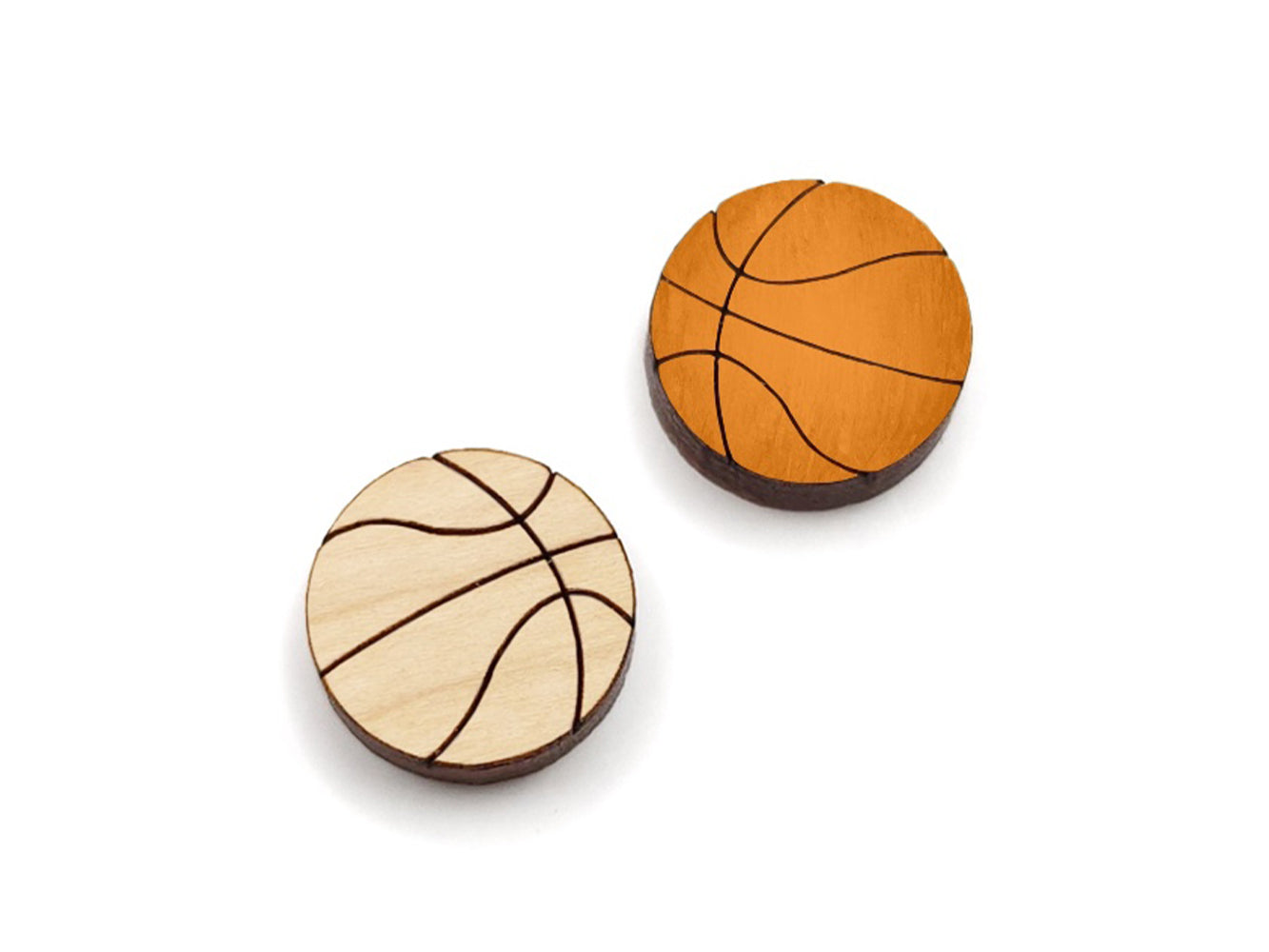 a pair of wooden cabochon stud earring blanks cut and engraved to look like basketballs