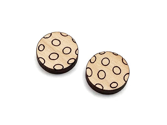 a pair of small wooden cabochon blanks for stud earrings, cut and engraved to look like pickleballs