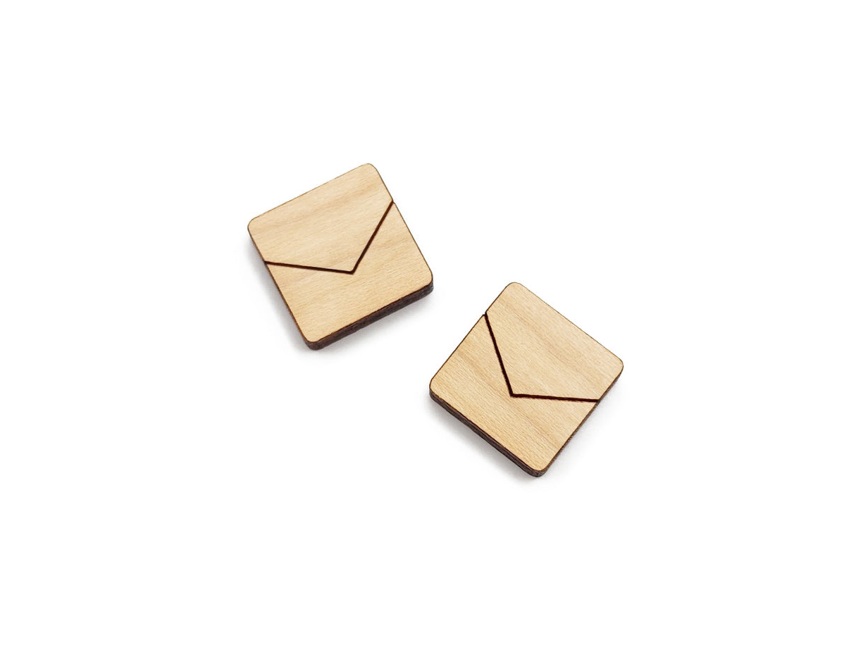 a pair of wooden cabochon stud earring blanks cut in a square shape and engraved with a chevron line