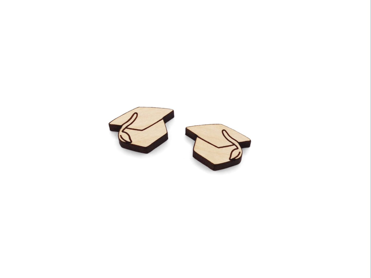 a pair of small wooden cabochon blanks cut and engraved to look like graduation caps