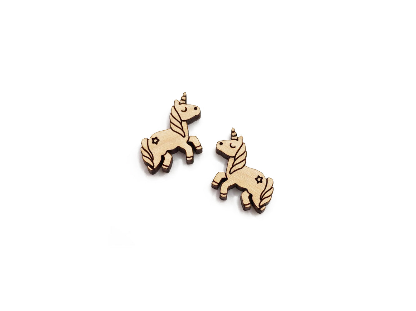 a pair of wooden cabochon stud earring blanks cut and engraved to look like a unicorn