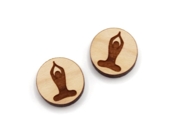 a pair of round wooden cabochon earring blanks engraved with a yoga pose silhouette design