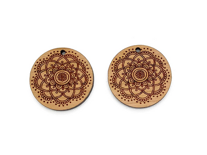 a pair of wooden earrings with a flower design