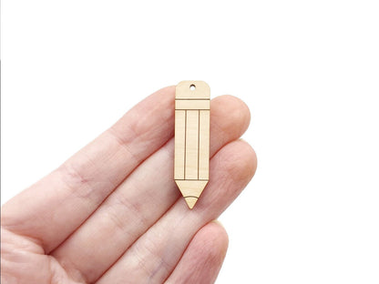 a hand holding a pair of wooden earring blanks cut and engraved to look like a pencil