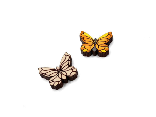 a pair of wooden cabochon stud earring blanks cut and engraved to look like butterflies