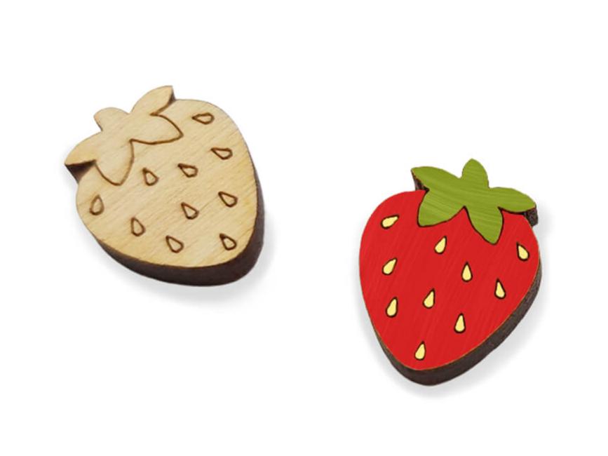 a pair of small wooden cabochon blanks for stud earrings, cut and engraved to look like strawberries