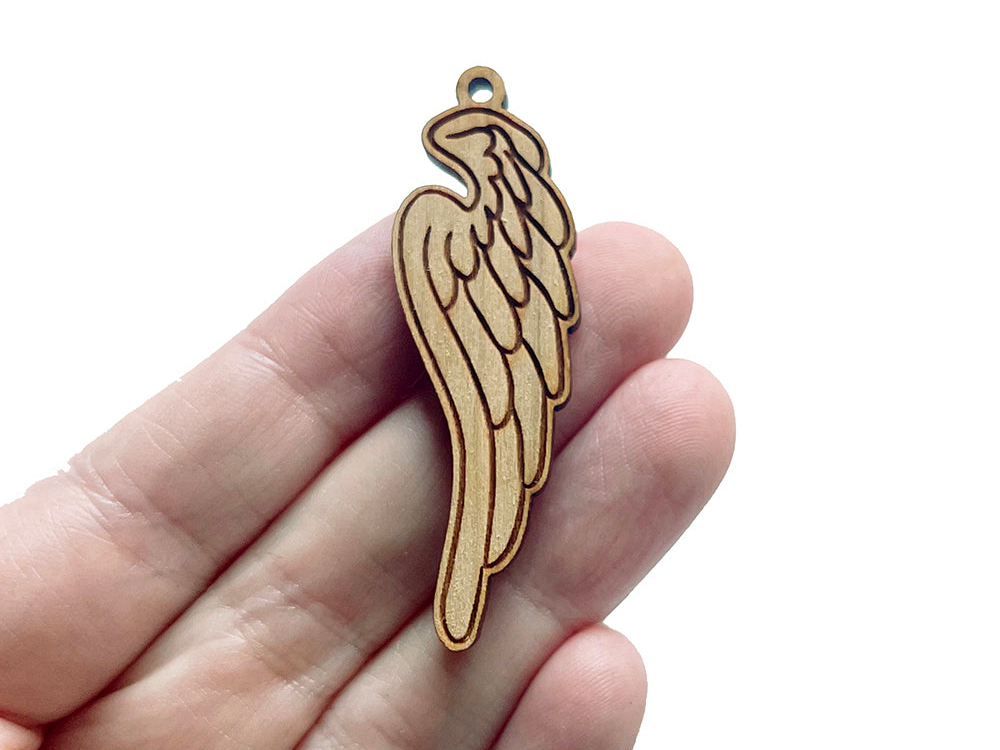 a hand holding a wooden angel ornament in it's palm