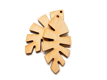 a wooden cutout of a leaf on a white background