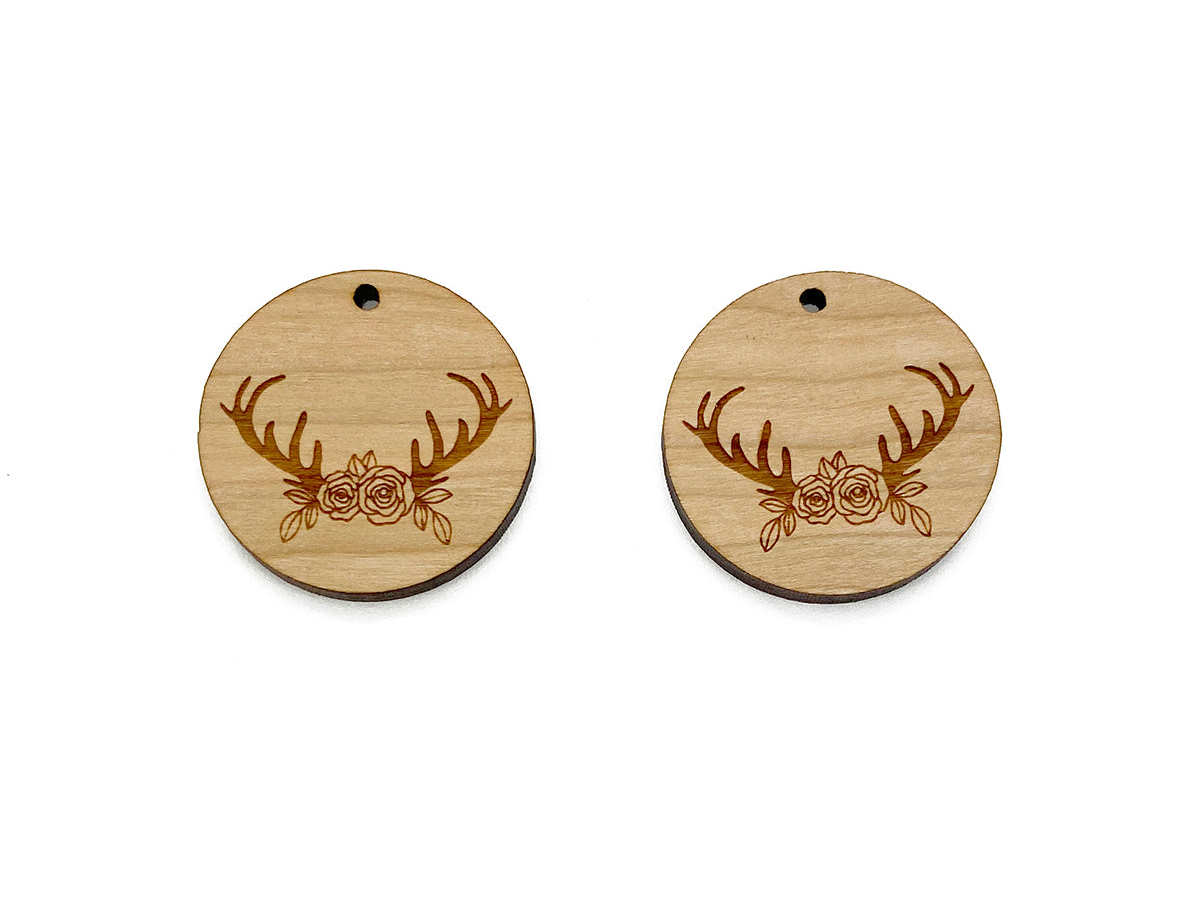 a pair of wooden earrings with deer antlers on them