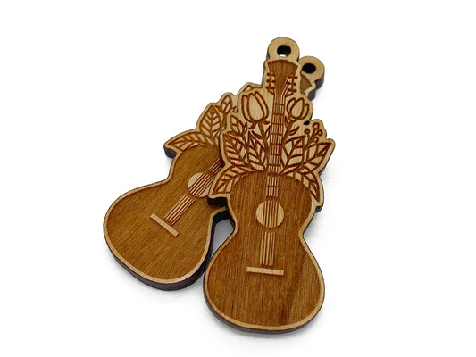 a pair of wooden guitar shaped magnets on a white background