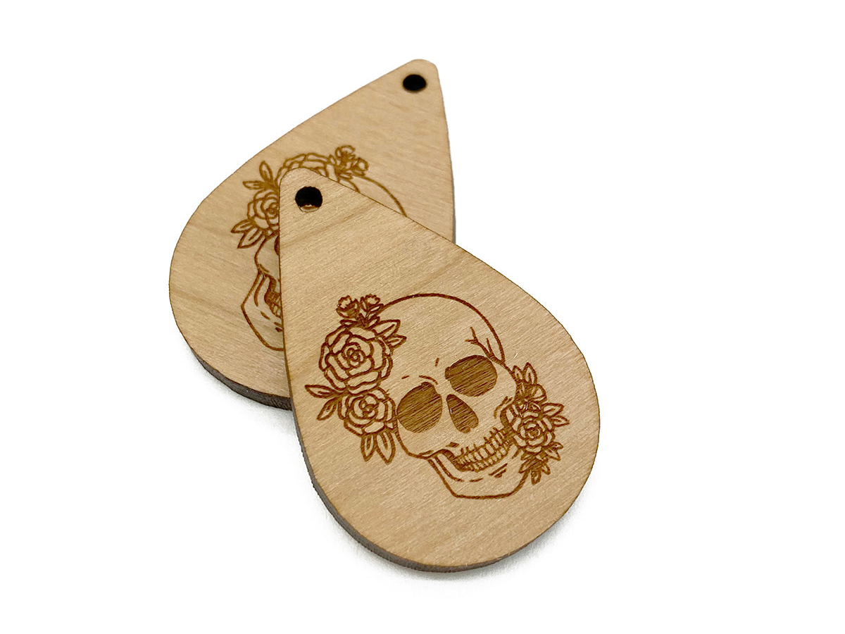 two wooden tags with a skull and roses on them