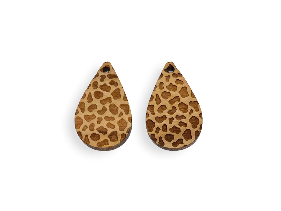 a pair of wooden earrings with a leopard print pattern