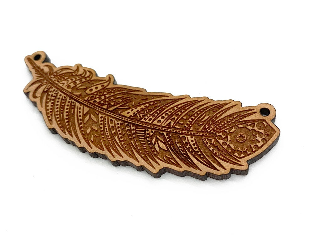 a wooden brooch with a leaf design on it
