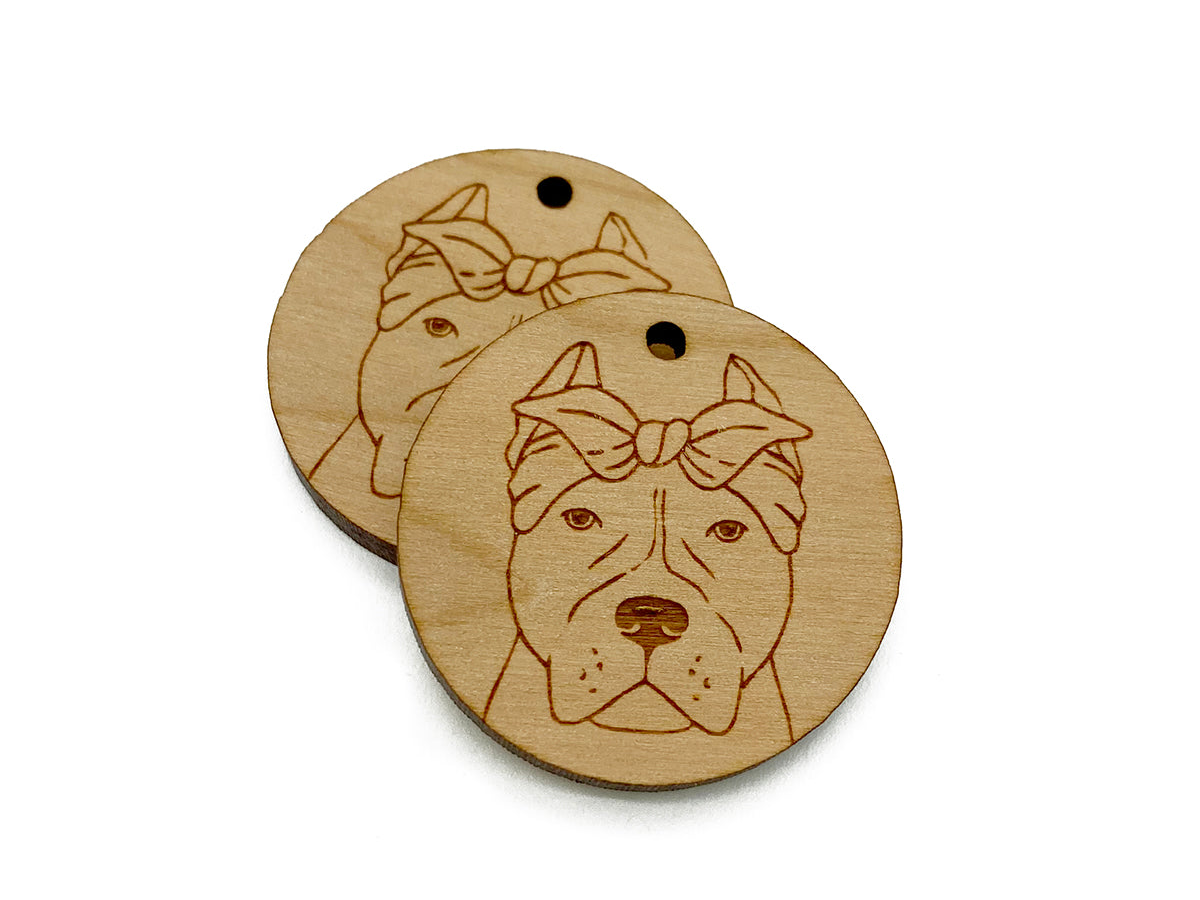 two wooden tags with a dog's face on them