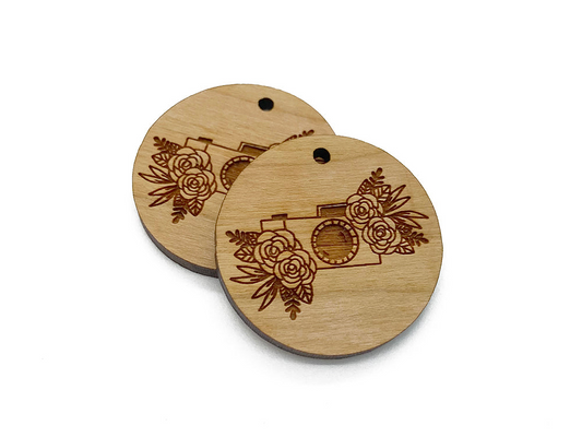 a couple of wooden tags with flowers on them