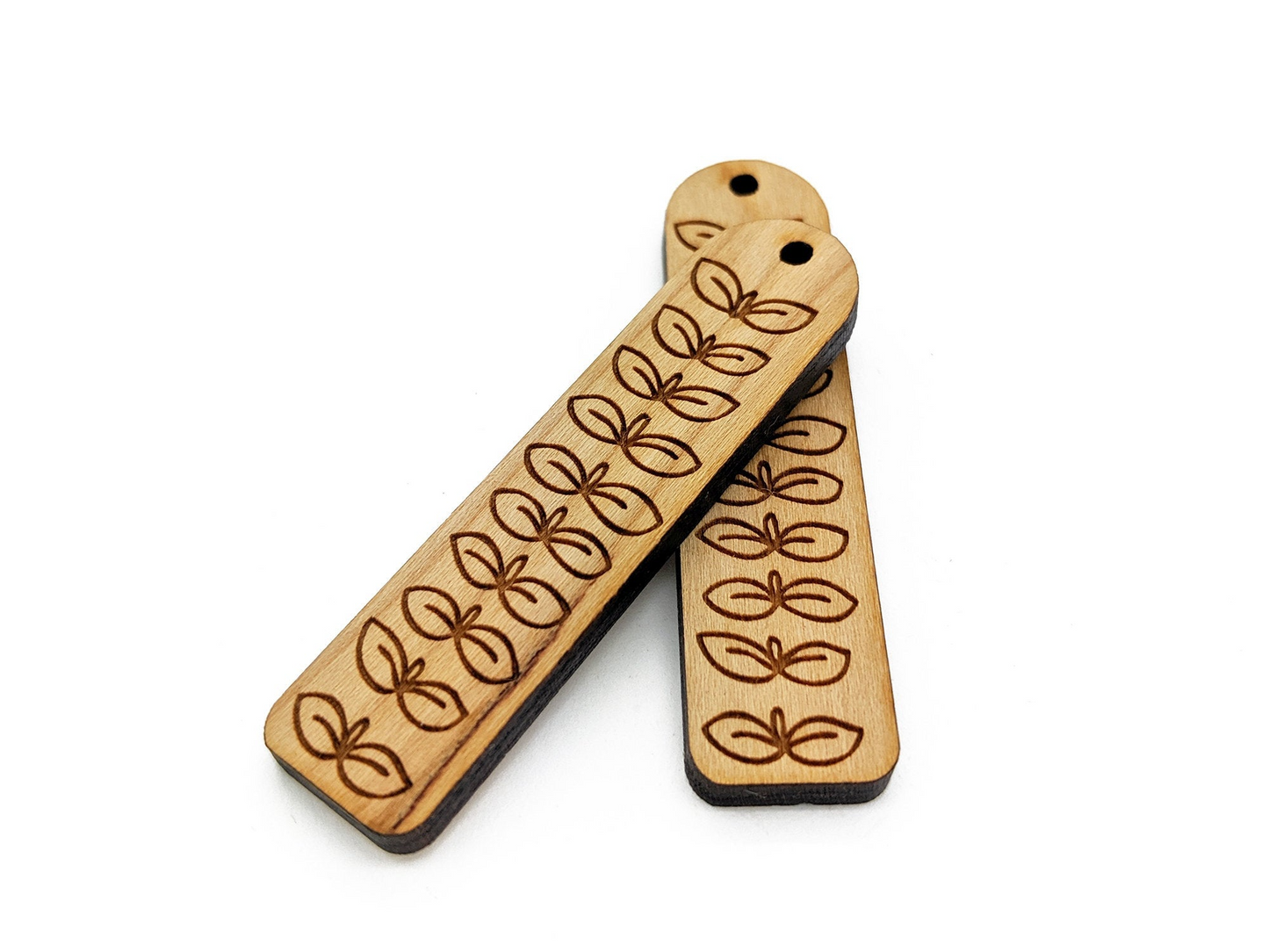 two wooden tags with a design on them