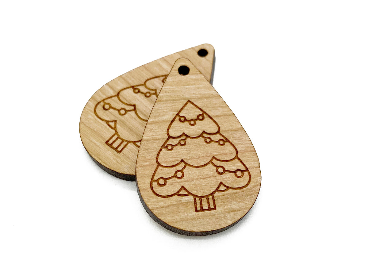 a pair of wooden earrings with christmas trees on them