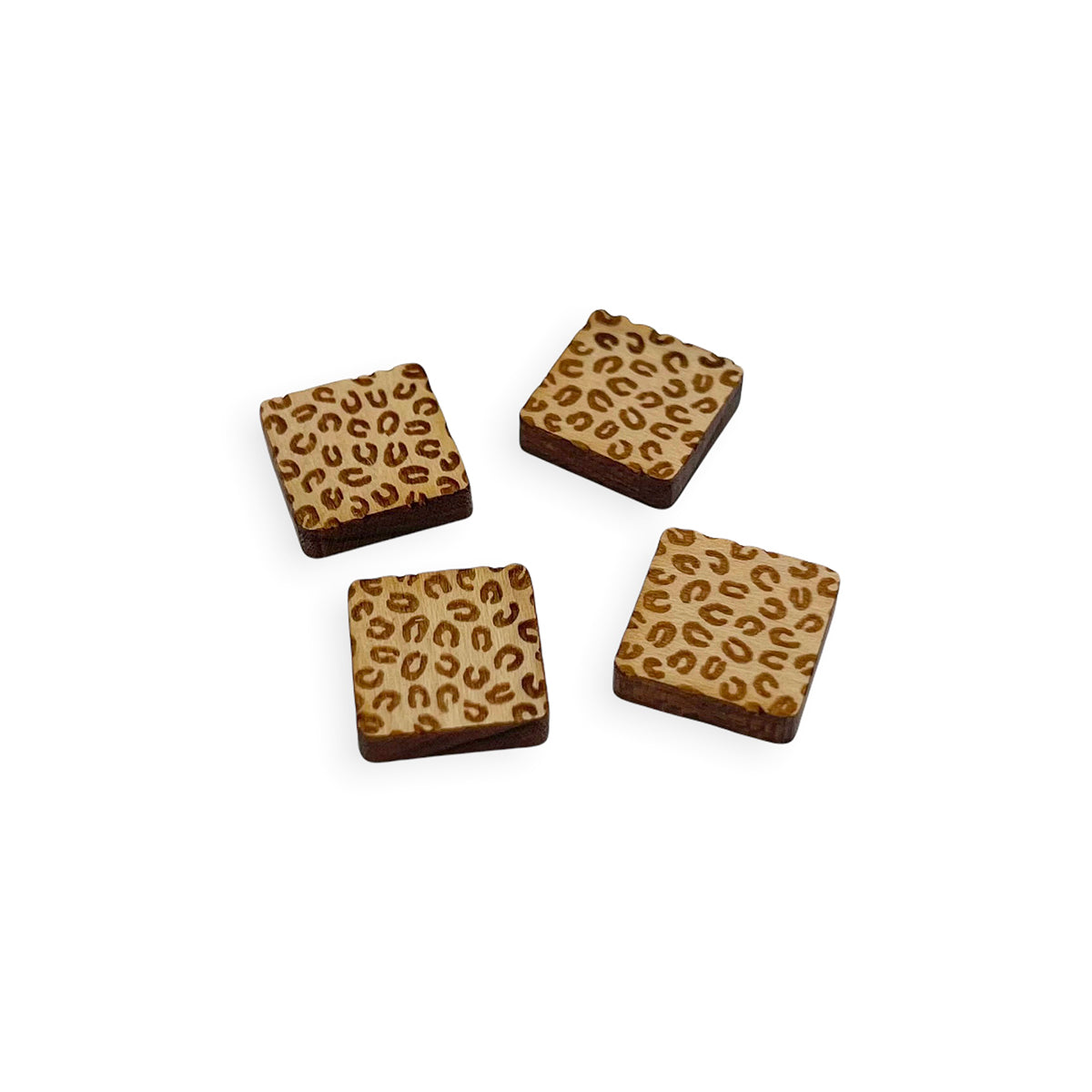 a pair of square wooden cabochon stud earring blanks engraved with a cheetah print pattern