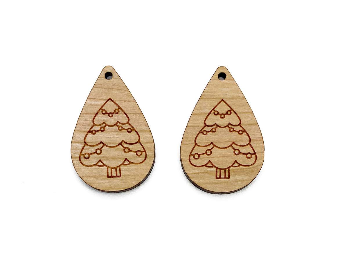 a pair of wooden earrings with christmas trees on them