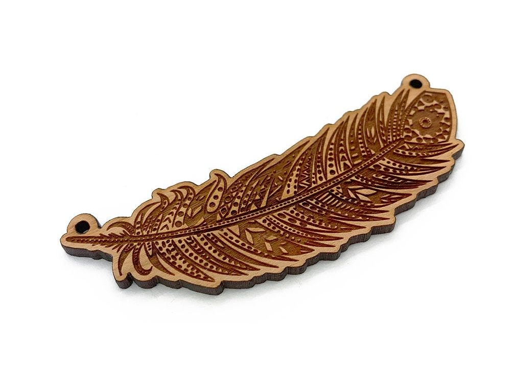 a wooden brooch with a brown feather on it