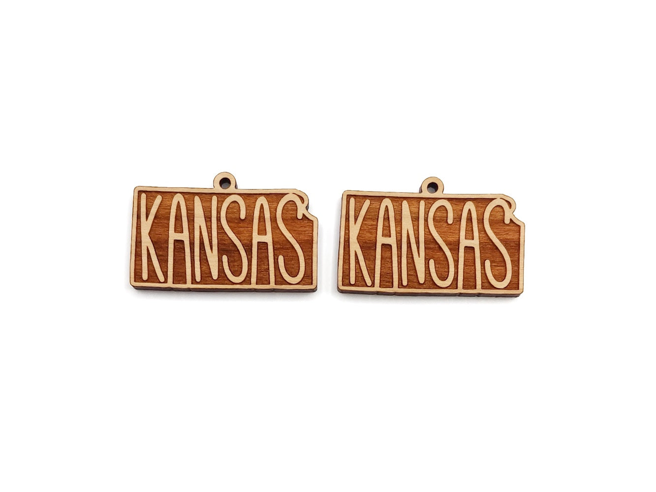 a pair of kansas wooden earrings on a white background